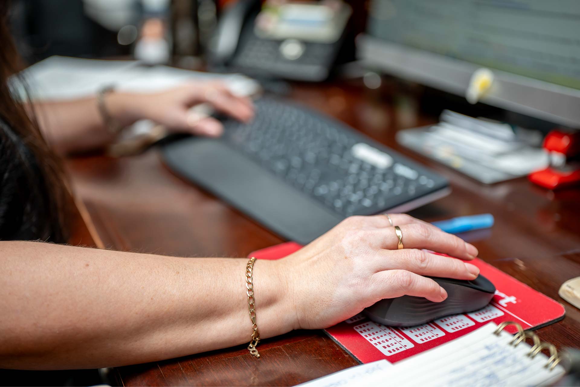 A close-up view of a loan specialist's hands using a keyboard and mouse at Direct Capital Lending, highlighting the detailed administrative work involved in securing a home loan.