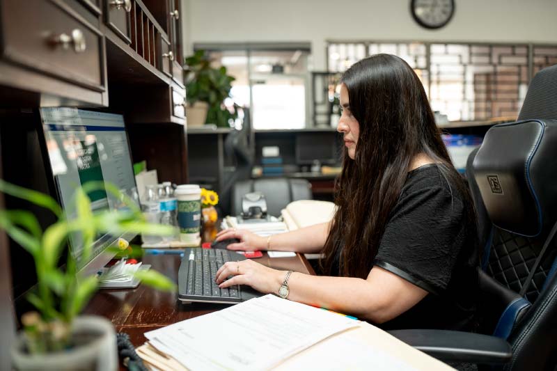 A mortgage specialist analyzing market rates on a desktop monitor at the Direct Capital Lending office to find the best financing solutions for clients.